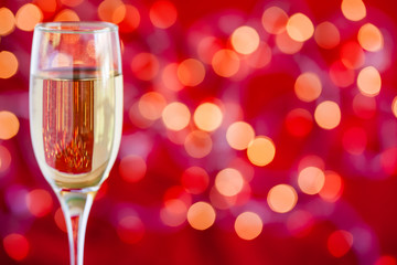 Champagne glass on light bokeh red background