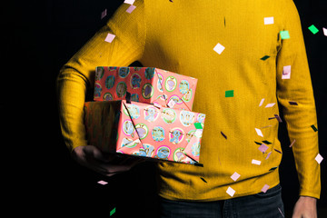 Young man in yellow sweater hold present for celebration