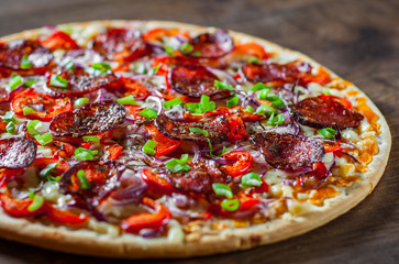 Pepperoni Pizza with Mozzarella cheese, salami, Tomato sauce, pepper, onion, Spices. Italian pizza on wooden table background