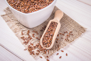 Linseed in a bowl on a wooden background.