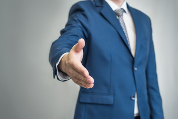 Businessman shaking hands, a man in a suit greets, stretches out his hand