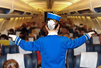 girl in costume stewardess shows the direction in the cabin