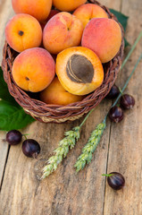 Delicious ripe apricots and berries on rustic background. Healthy foods
