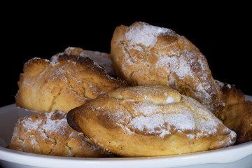 Traditional Cypriot pastry İci Dolu with walnut inside and powder sugar on top with isolated black background