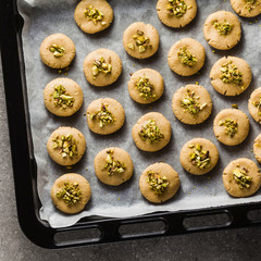 homemade cookies, almond and sesame biscuits with pistachios. healthy vegan gluten free pastries on a baking tray
