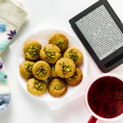 homemade cookies, almond and sesame biscuits with pistachios. healthy vegan gluten free pastries served with fresh raspberry tea. E-book and warm wool socks with a pattern. 