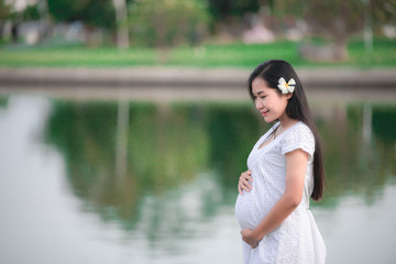 Portrait of young pregnant  woman play yoga at the park,Thailand people