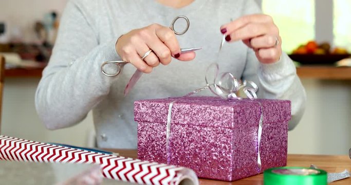 Close Up Of Woman At Home Gift Wrapping Present