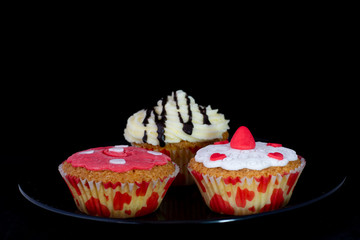 Fresh baked delicious different cupcakes served together with isolated black background