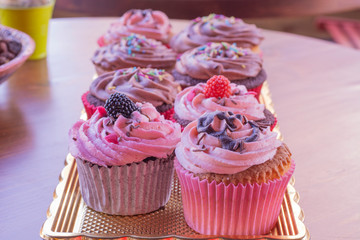 Fresh baked delicious different cupcakes served together with wood background