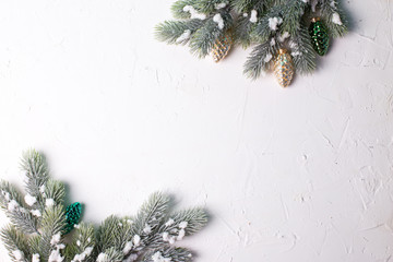 Frame from christmas decorative golden and green  pine cones and branches fir tree on  white textured  background.