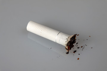 Healthy lifestyle concept. A small stub lies on a light surface, a row of a little ash.