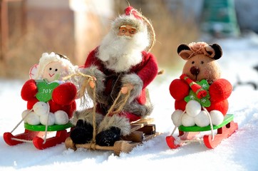Christmas toys Santa Claus, angel, bear, in a sleigh, in a snowy forest, outdoors.