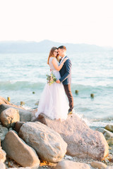 young beautiful wedding couple in blue clothes posing near the Garda lake in Sirmione