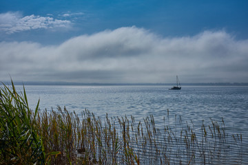 Nebel-, Wolkenstimmung mit Segelboot am Starnberger See