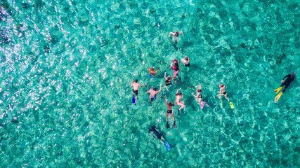 Aerial drone view of group of people snorkelling in tropical blue waters in the Caribbean Sea