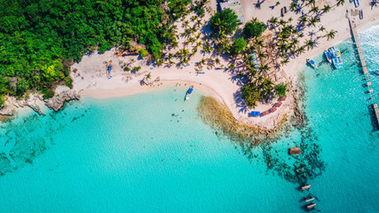 Aerial drone view of Saona Island in Punta Cana, Dominican Republic with reef, trees and beach in a tropical landscape with boats and vegetation - obrazy, fototapety, plakaty