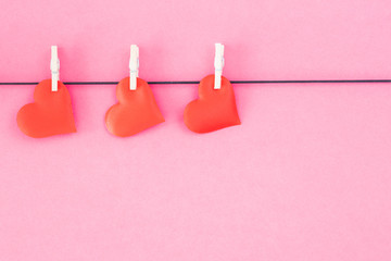 Hearts hanged on a pink background. Valentines Day concept.