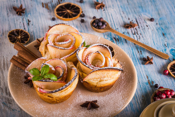 Crispy apple roses on color plate with several herbs and spices