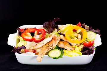 Grilled Chicken Salad with fresh vegetables with isolated black background