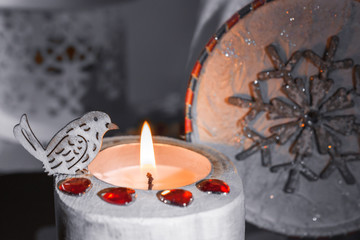 Wooden Christmas candle with a bird on the background of the box with sweets.