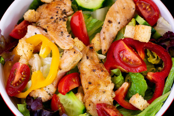 Grilled Chicken Salad with fresh vegetables with isolated black background