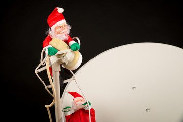 Santa climbing onto a satellite dish, a  globalization concept