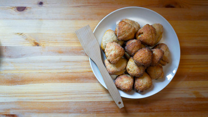 Baked delicious cookies. Large number. Lie on a white plate. Wooden table. Appetizing dish. Home cozy atmosphere. The view from the top.  
