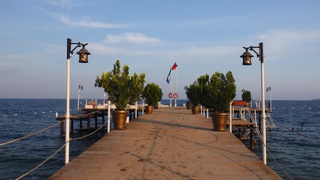 Tourists rest on the pier near the sea