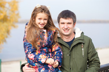 Father and little daughter in autumn park