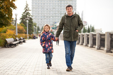 Father and little daughter in autumn park