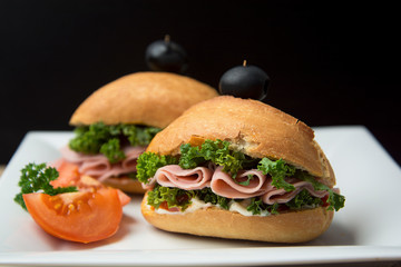 Homemade burger. Low fat turkey ham and salad sandwich, black background. Food photo.