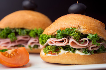 Homemade burger. Low fat turkey ham and salad sandwich, black background. Food photo.