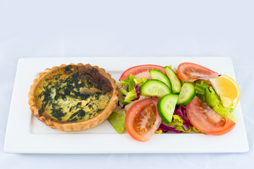 Spinach pie served with fresh salad with isolated white background