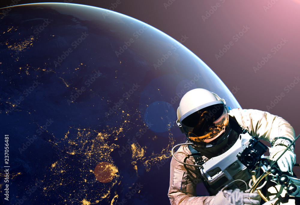 Wall mural astronaut spacewalk at night from the dark side of the earth planet. elements of this image furnishe