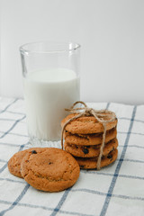 food, fast food, cooking, baking and food concept-close up of chocolate oatmeal cookies and milk in a glass