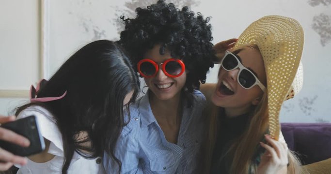 three female friends making selfies indoor