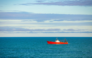 Obraz premium Red fishing boat on the high seas