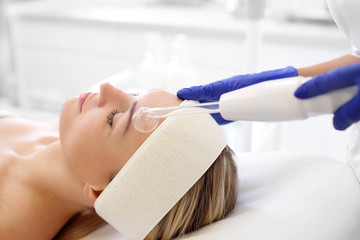 Biofuzja tlenowa.  Kobieta w salonie kosmetycznym podczas zabiegu pielęgnacyjnego z użyciem aktywnego tlenu - obrazy, fototapety, plakaty