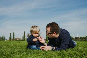 .Father and son playing on the grass a nice autumn morning. Sharing happy moments together. Lifestyle.