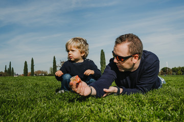 Naklejka na ściany i meble .Father and son playing on the grass a nice autumn morning. Sharing happy moments together. Lifestyle.