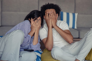 Young couple at home watching a movie with popcorn