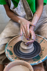 Vertical high angle above top view lady in her workwear she sit inside workspace transform piece of mud in beautiful small tea cup by hands