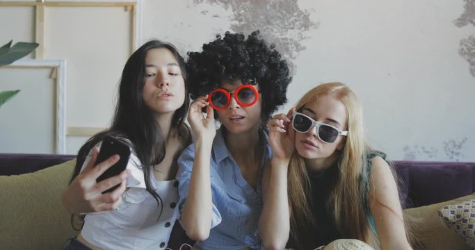 three female friends making selfies indoor