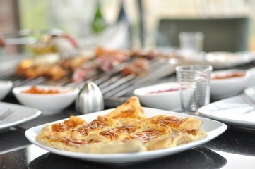 Traditional Cypriot meze and mix meat and chicken kebab table with charcoal barbecue on the table for self cooking during the eating time