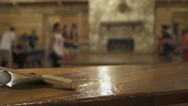 Slider Shot Of Ping Pong Paddle With Teens Playing In Background 1