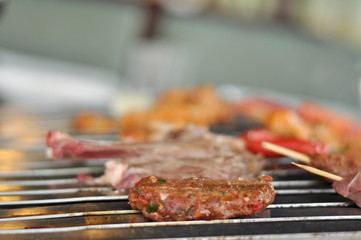 Traditional Cypriot meze and mix meat and chicken kebab table with charcoal barbecue on the table for self cooking during the eating time