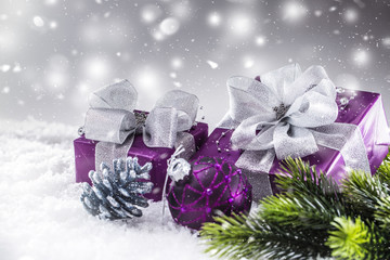 Christmas luxury purple gifts in snow and abstract snowy atmosphere