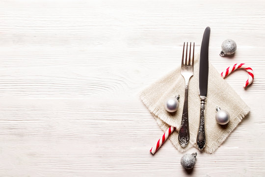 Christmas table setting conceptual design with fork, knife and festive attributes. New Year banquet serving appointment options with silverware. Background, close up, top view, flat lay, copy space.