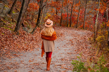 Beautiful woman traveler is walking in the autumn forest.